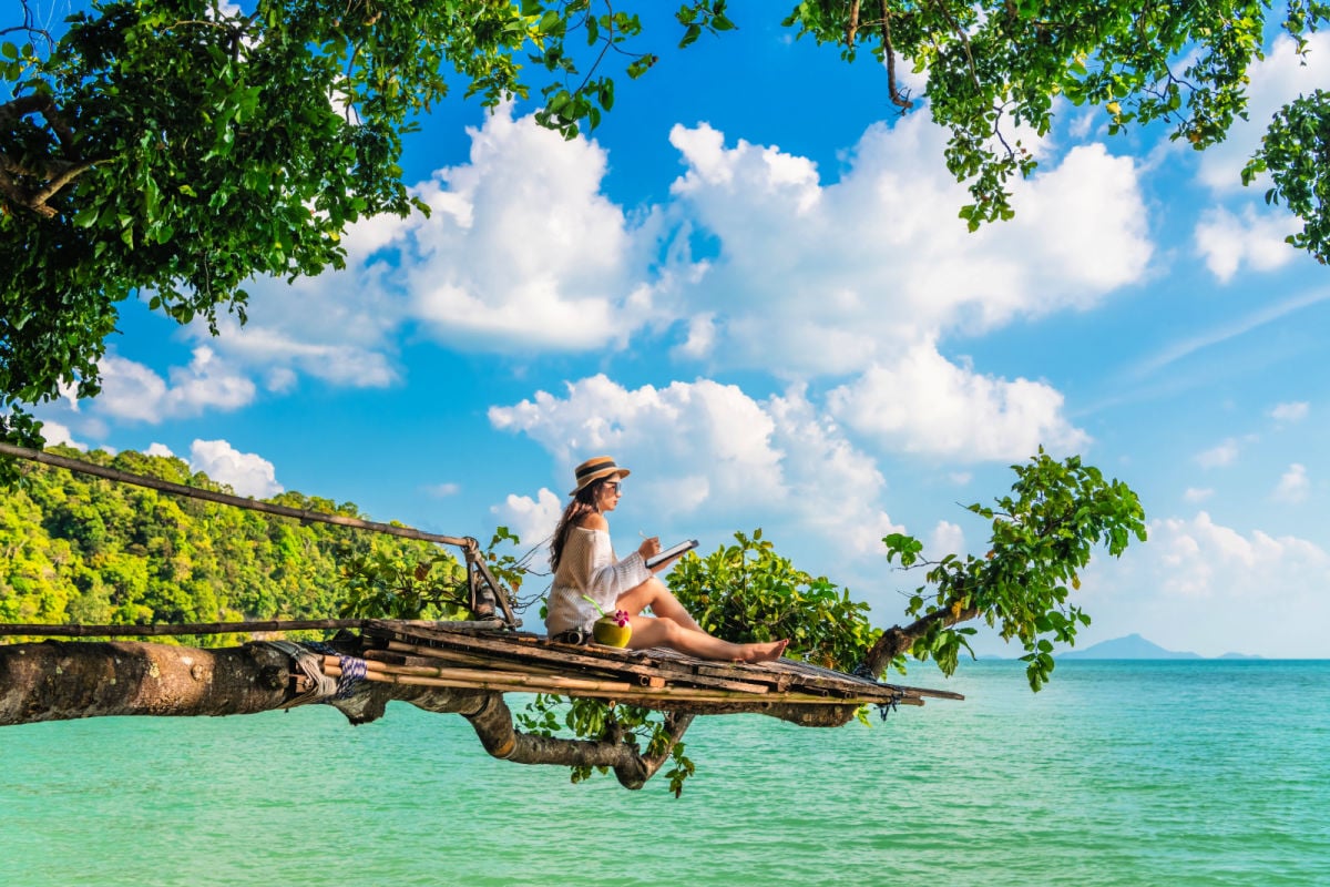 Digital nomad in Thailand on a tree overlooking ocean